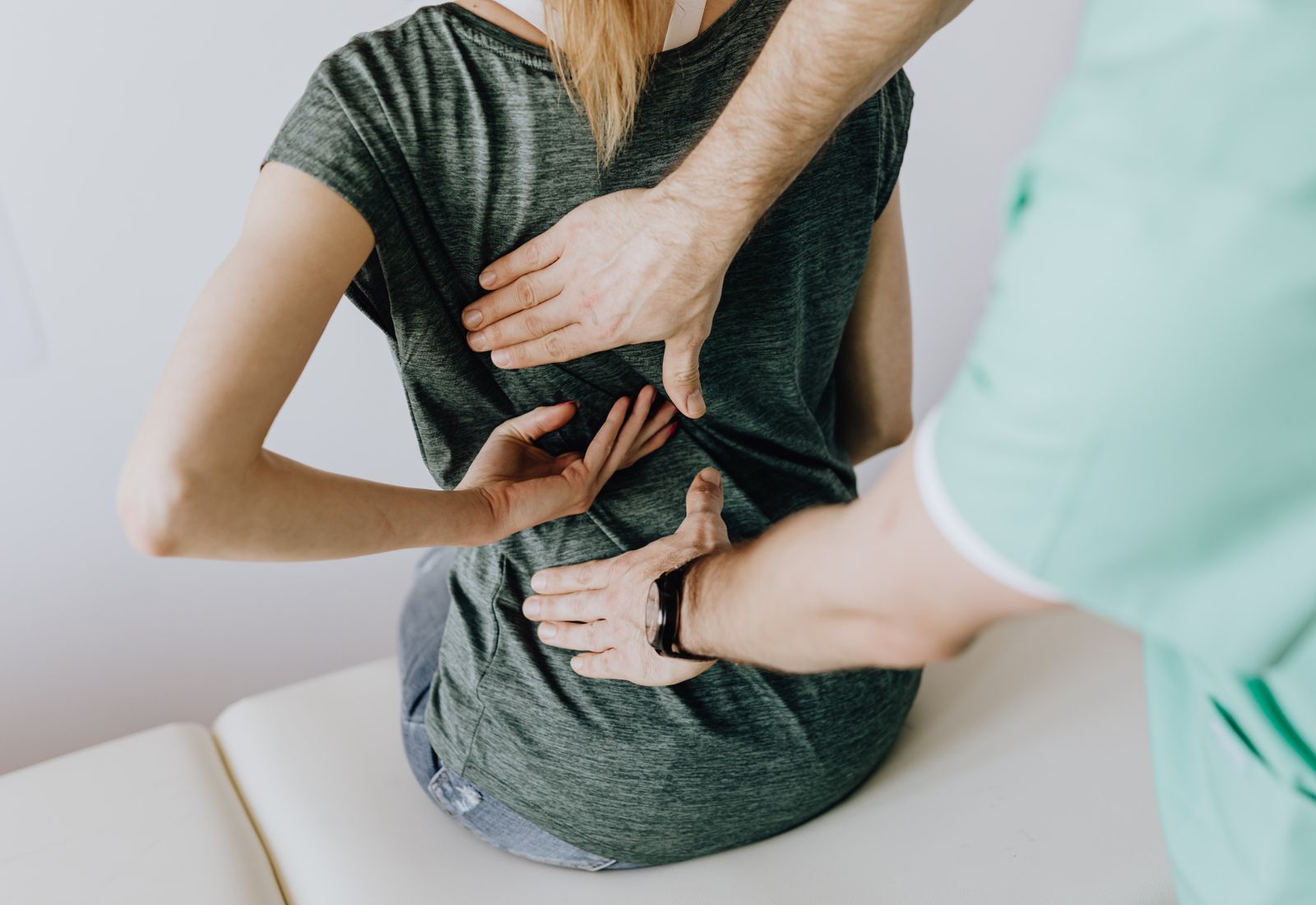 A chiropractor treating a patient's neck and shoulders in a bright clinic