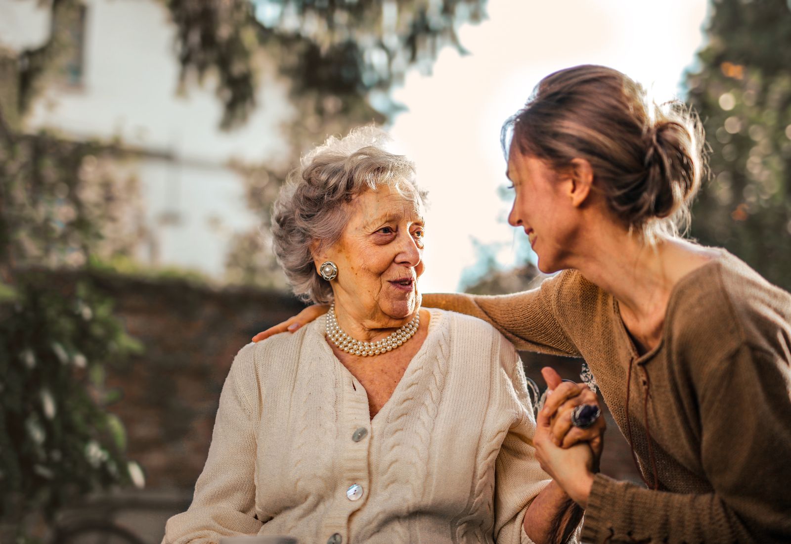 An older patient smiling warmly with a caregiver
