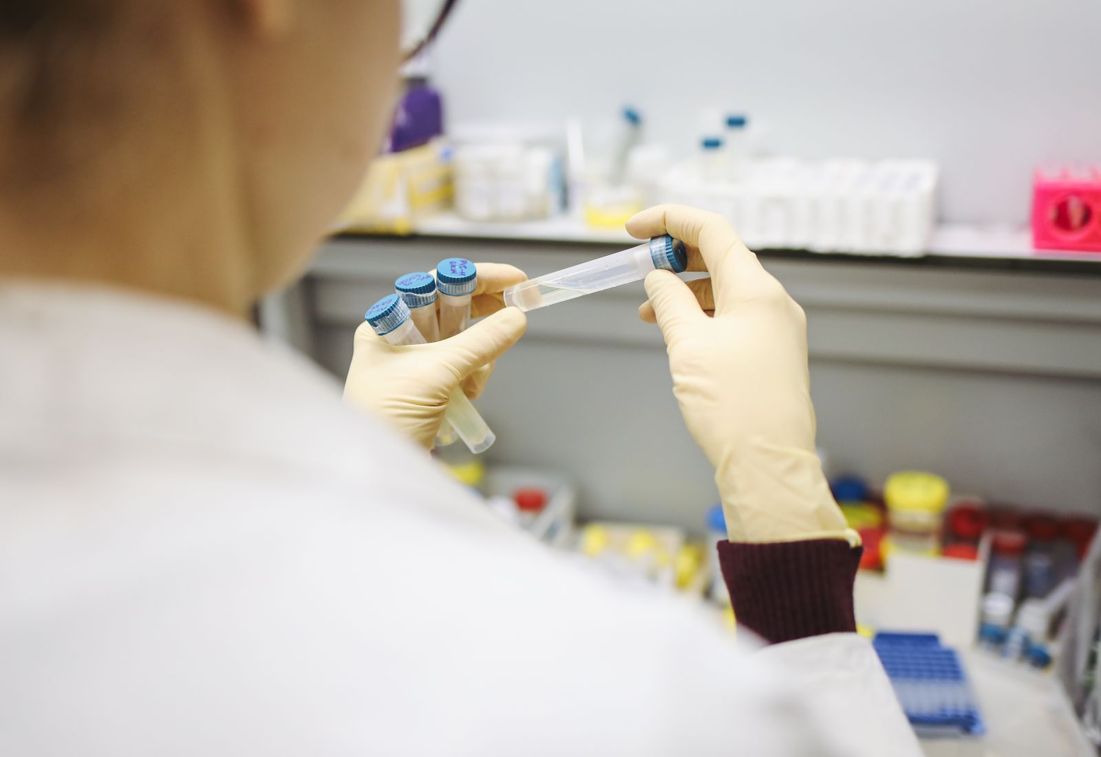 Pharmacy technician preparing a compounded prescription with a pipette and vials