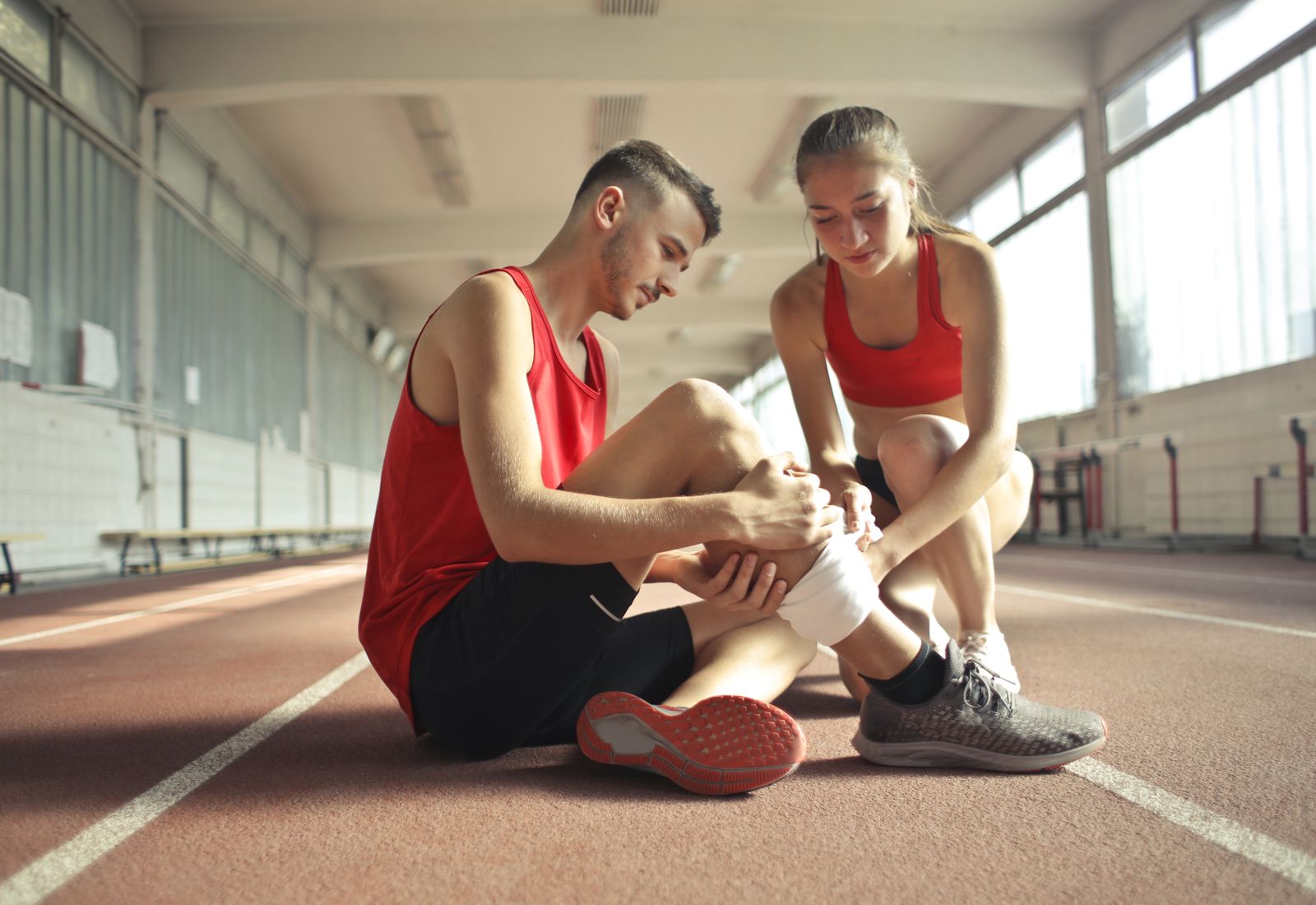 Physical therapist assisting an athlete with a knee during rehabilitation